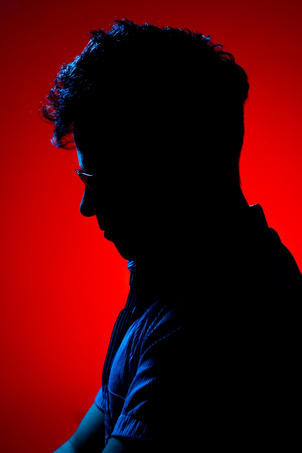 Retrato de estudio a contraluz sobre fondo rojo