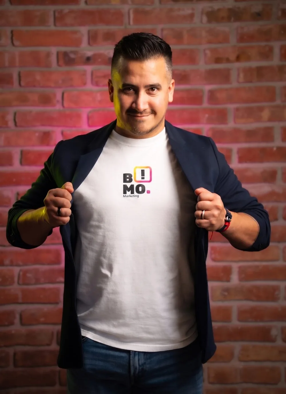 Víctor Castilla con playera de B!MO Marketing frente a un muro de ladrillo